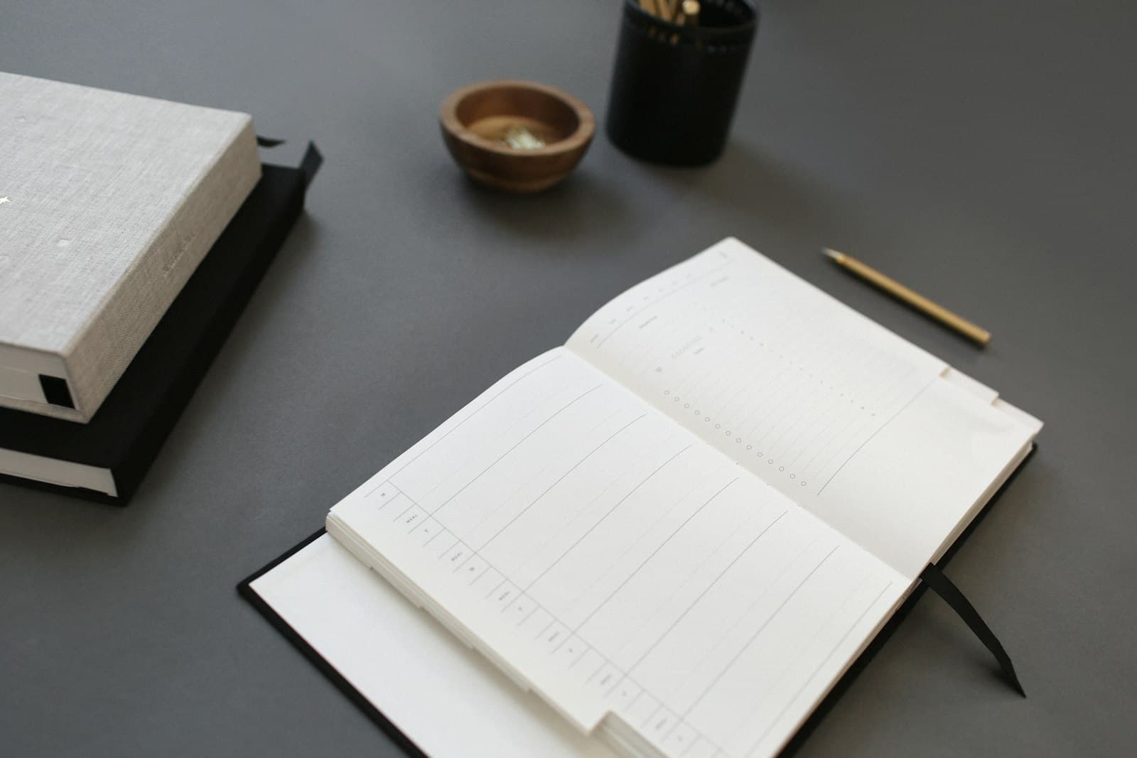 Un cuaderno de registro abierto sobre un escritorio, junto a un lápiz